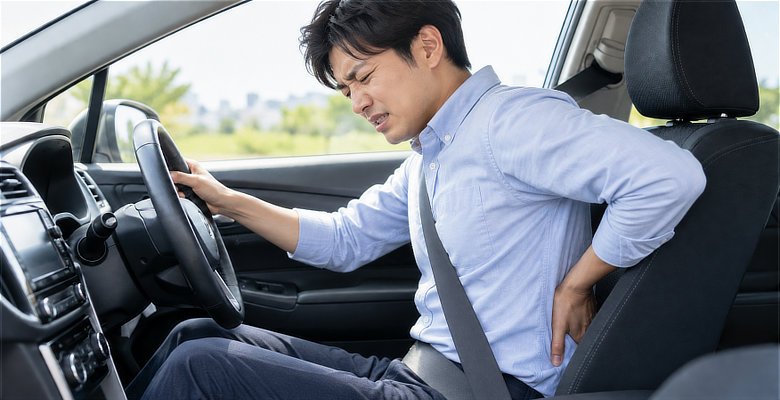車の運転中に腰の痛みを感じる男性